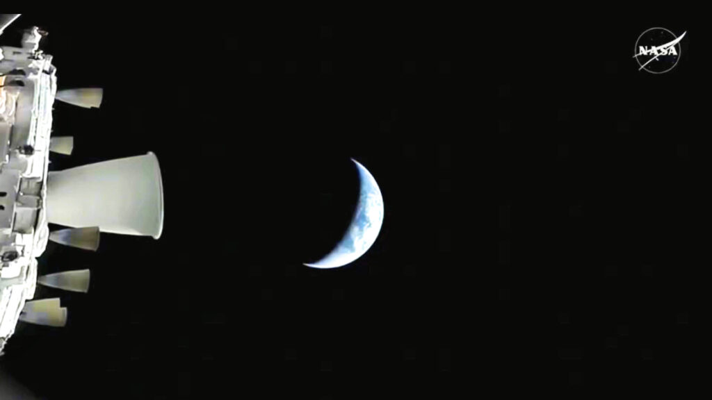 Fotografia do espaço mostrando a nave Orion da missão Artemis II em trajetória de afastamento do planeta Terra. Imagem oficial da NASA